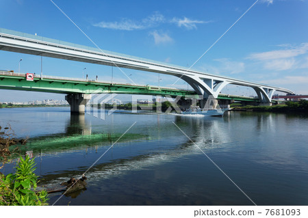A fishing boat sailing under a fan bridge over Arakawa and a scenery reflected on the river surface 7681093