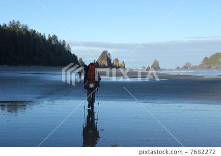 Backpackers walking on the beach 7682272