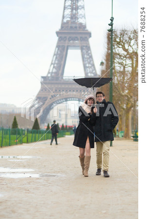 Couple walking under the rain with broken umbrella 7688254