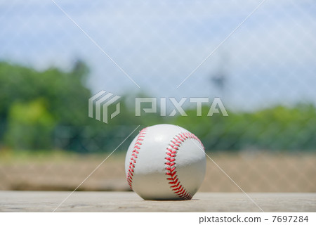 A baseball, a blue sky, and a baseball field. A baseball, a blue sky, and a baseball field. 7697284