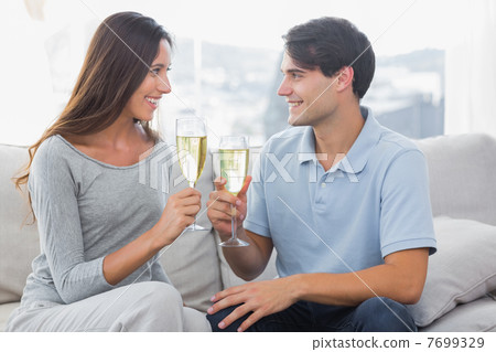 Lovers clinking their flutes of champagne 7699329