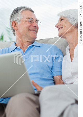 Couple using a laptop pc on the couch 7699438