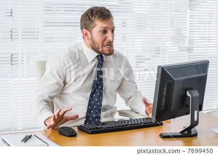 Frustrated businessman looking at his computer Frustrated businessman looking at his computer 7699450