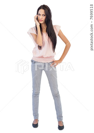 Serious woman calling someone with her mobile phone Serious woman calling someone with her mobile phone 7699518