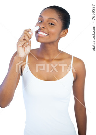 Smiling woman smelling her lip balm Smiling woman smelling her lip balm 7699587