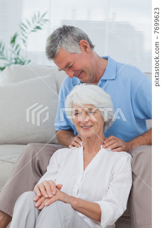 Man giving a shoulder massage to his wife Man giving a shoulder massage to his wife 7699623