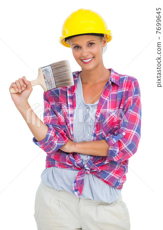 Attractive handy woman holding a brush and smiling at camera Attractive handy woman holding a brush and smiling at camera 7699645