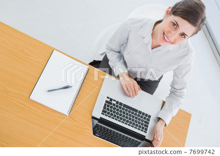 Pretty businesswoman smiling up at camera Pretty businesswoman smiling up at camera 7699742