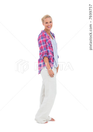 Blonde woman standing and smiling at camera 7699757