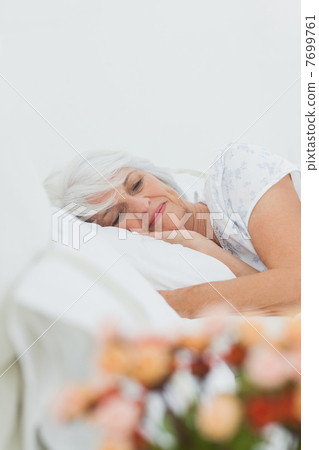 Peaceful woman sleeping in bed 7699761