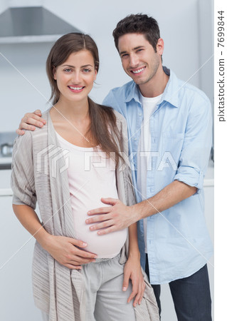Man touching the belly of his pregnant wife 7699844