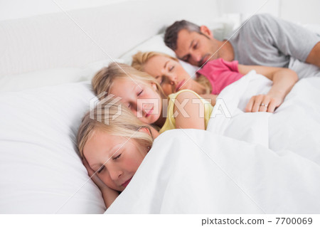 Parents sleeping with their children in bed 7700069