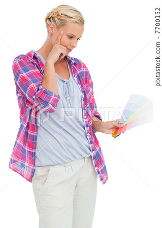 Serious blonde looking at color charts 7700152