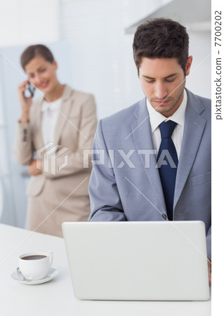 Businessman using a laptop before going to work Businessman using a laptop before going to work 7700202
