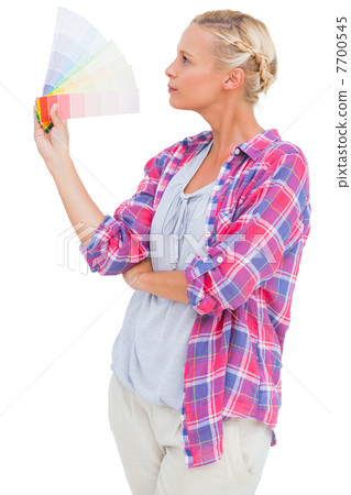 Blonde looking at colour charts and picking colour Blonde looking at colour charts and picking colour 7700545