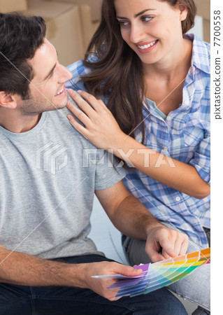 Happy couple looking at color samples to decorate their house 7700558