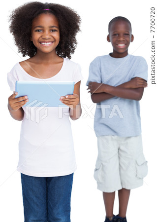 Smiling girl holding tablet pc with her brother 7700720