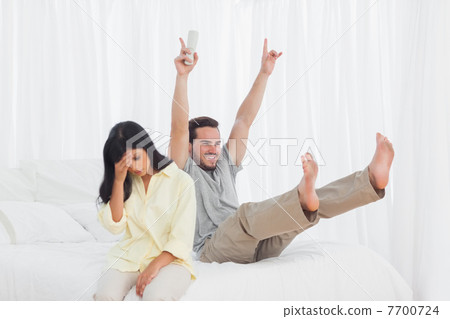 Woman annoyed at her partner watching tv 7700724