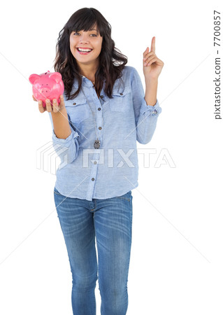 Smiling young woman with piggy bank pointing her finger 7700857