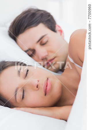 Portrait of a pretty woman sleeping next to her partner Portrait of a pretty woman sleeping next to her partner 7700960