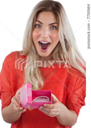 Surprised woman discovering necklace on a box Surprised woman discovering necklace on a box 7700964