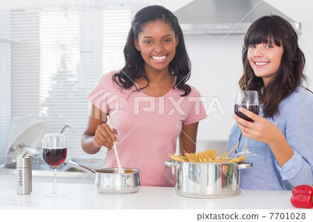 Happy friends preparing dinner together 7701028