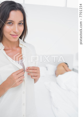Portrait of a woman sneaking out of bed Portrait of a woman sneaking out of bed 7701154