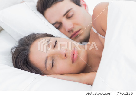 Portrait of an attractive woman sleeping next to her partner Portrait of an attractive woman sleeping next to her partner 7701236