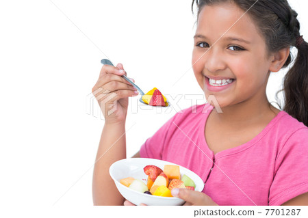 Smiling little girl eating fruit salad Smiling little girl eating fruit salad 7701287