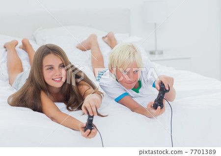 Siblings playing video games 7701389