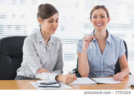 Smiling businesswomen working on documents 7701826