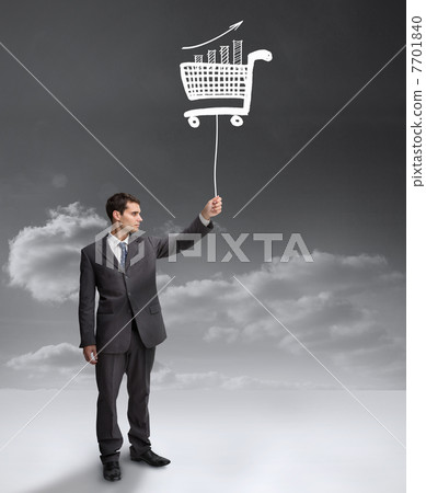 Businessman holding a floating shopping cart 7701840