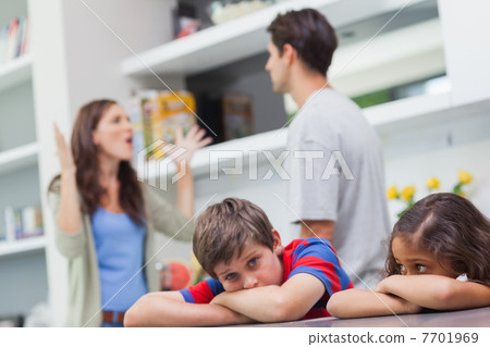 Couple arguing behind their children 7701969