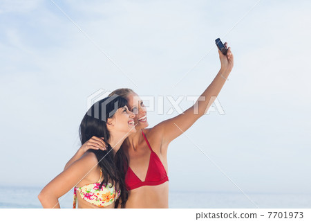 Women taking picture and smiling 7701973