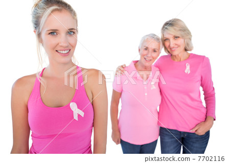 Three happy women wearing pink tops and breast cancer ribbons Three happy women wearing pink tops and breast cancer ribbons 7702116