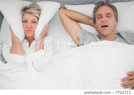 Man snoring loudly as partner blocks her ears 7702211