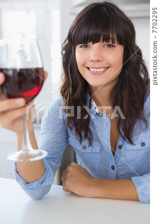 Attractive brunette having glass of red wine 7702295