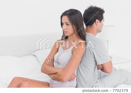 Unhappy couple ignoring each other sitting back to back Unhappy couple ignoring each other sitting back to back 7702379
