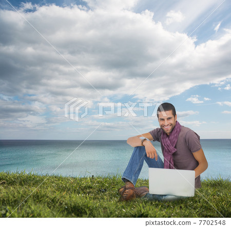 Handsome man sitting on the grass Handsome man sitting on the grass 7702548