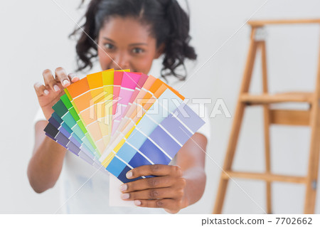Excited woman showing colour charts 7702662