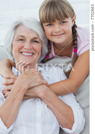 Young girl hugging her grandmother 7702663
