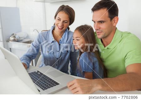 Family using a laptop pc in the kitchen Family using a laptop pc in the kitchen 7702806