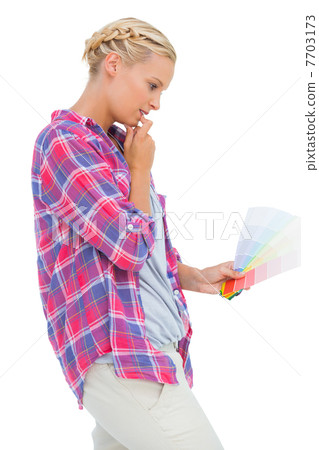 Concentrated young woman looking at color charts Concentrated young woman looking at color charts 7703173