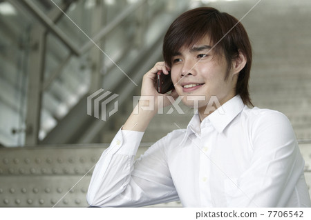 Asian Business man using a Cell Phone Asian Business man using a Cell Phone 7706542