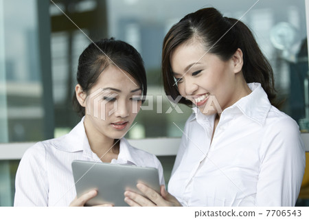Asian Business people using Touch-pad PC Asian Business people using Touch-pad PC 7706543