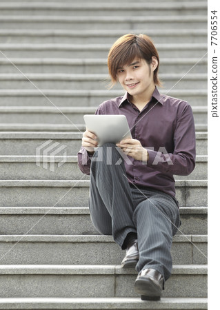 Asian Business man using a Digital Tablet Asian Business man using a Digital Tablet 7706554