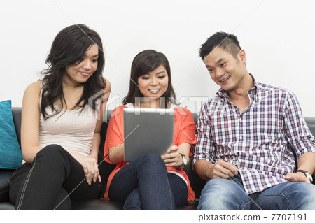 Chinese friends hanging out together using Digital Tablet 7707191