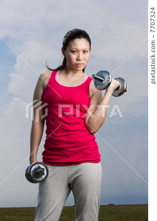 Chinese woman exercising with dumbbells. Chinese woman exercising with dumbbells. 7707324