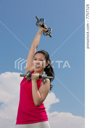 Chinese woman exercising with dumbbells. Chinese woman exercising with dumbbells. 7707326