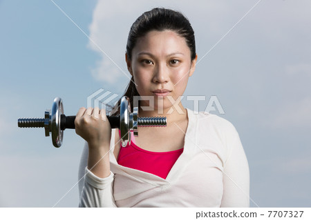 Chinese woman exercising with dumbbells. 7707327